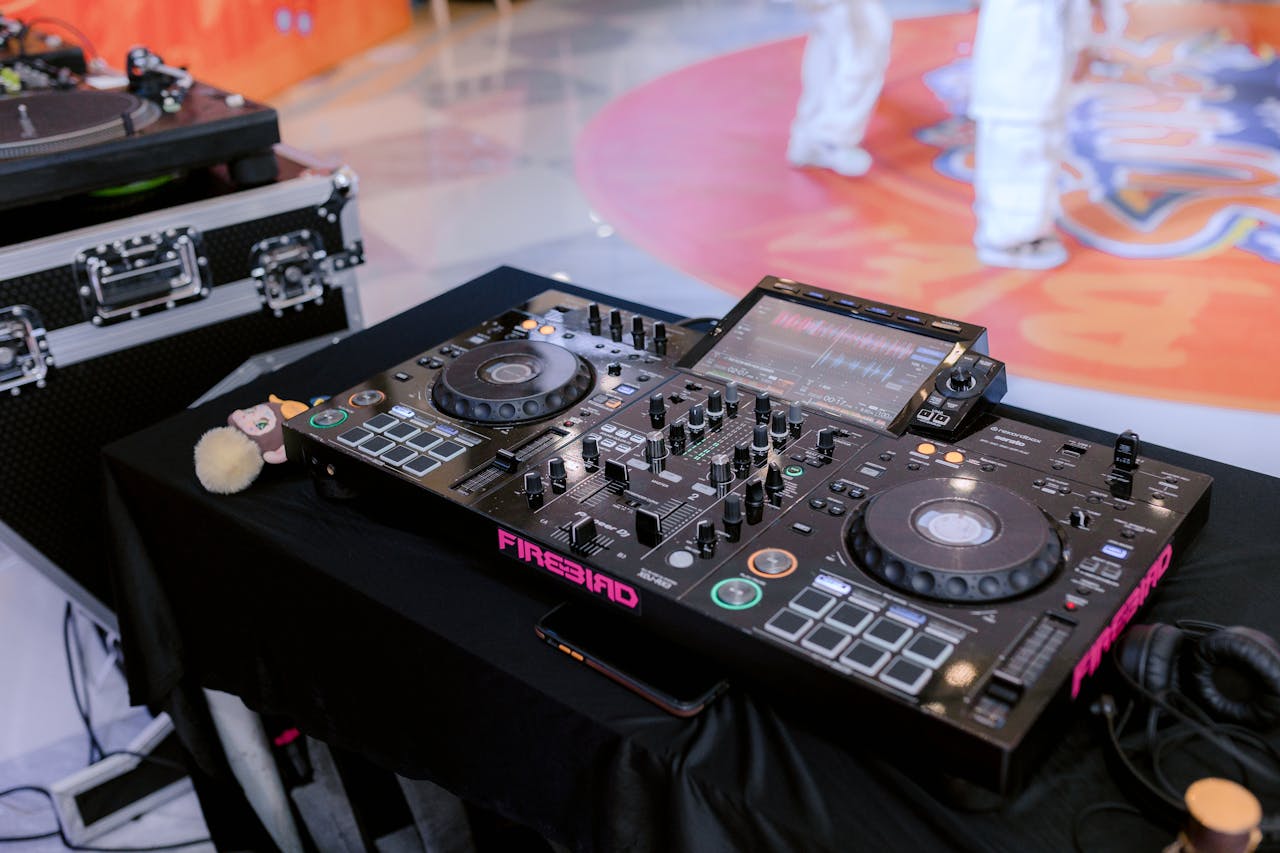 Close-up of professional DJ equipment setup, highlighting a digital mixer and turntable at an indoor event.