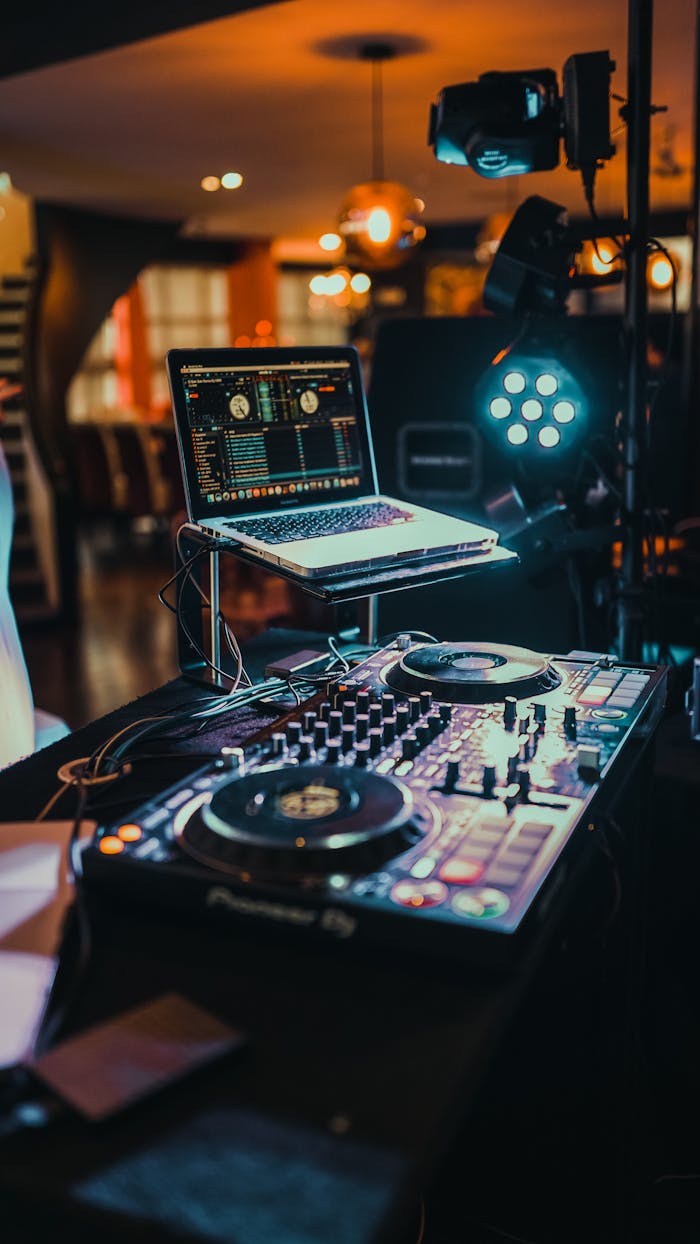 A vibrant indoor DJ booth with a laptop and music controller ready for use.